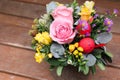 Festive flower arrangement of pink roses, yellow freesia flowers, eucalyptus leaves and other plants with red Easter eggs Royalty Free Stock Photo