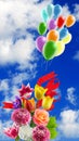 festive flowers and bright multi-colored inflatable balls against the background of the sky with clouds