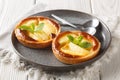 Festive fresh apple tartlets with custard decorated with mint close-up in a plate. Horizontal