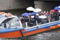 Festive fun event on the water tram with costumed people colorfully dressed and with umbrellas.