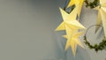 Festive garland in the form of golden star with light, wreaths for Christmas, New Year on grey background.