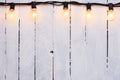 Festive garland glass lamps on wooden white painted wall