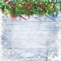 Festive garland with holly, lights and firtree on a snowy wooden background