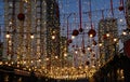 Through the festive garlands and balloons one can see the evening city. City at dusk decorated to celebrate Christmas and New Year