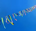 Festive garlands, fluttering colored ribbons, blue sky background, website cover about joyful mood, festival Royalty Free Stock Photo