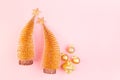 Festive gentle New Year background with glitter glossy gold decorations, Christmas trees on pink backdrop, top view. Royalty Free Stock Photo