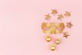 Festive gentle New Year background with glitter gold masquerade mask, stars , balls on pink backdrop, top view. Royalty Free Stock Photo