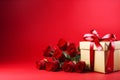 Festive gift present box with a white ribbon and bow and beautiful roses on red banner background with empty copy space for text Royalty Free Stock Photo