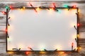 Festive Glow - Christmas Lights Bulb Frame on White Wood, Merry Christmas and New Year Holiday Background. created with Generative Royalty Free Stock Photo