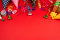 Festive golden and purple stars of confetti  and a present, birthday caps on a red background Royalty Free Stock Photo