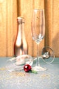 Festive golden silver Christmas New Year background with glassware. Two empty shiny wine glasses and a bottle of