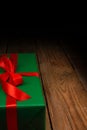 Festive green gift box with red satin bow, ribbon. Place for text, advertising. Holiday concept. A gift on a Royalty Free Stock Photo