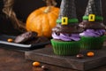 Festive Halloween cupcakes with wafer witch hats and candy