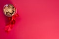 Festive heart-shaped cookies in a jar with a red bow on a red background. With space for text