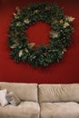 Festive home interior design concept. Christmas wreath on the wall in the living room. Christmas and New Year celebration decorat