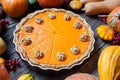 Festive Homemade Delicious Pumpkin pie with walnuts made for Thanksgiving and halloween, top view. Autumn composition.