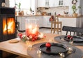Festive interior of house is decorated for Christmas and New Year in loft style with black stove, fireplace, Christmas tree. Warm Royalty Free Stock Photo