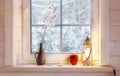 Festive lantern, red mug and heart on a wooden window sill in winter indoors. Royalty Free Stock Photo