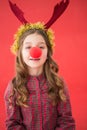 Festive little girl wearing red nose