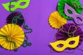 Festive Mardi Gras masquerade purple background. Fat Tuesday carnival, masks, beads, traditional decor Royalty Free Stock Photo