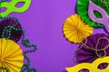 Festive Mardi Gras masquerade purple background. Fat Tuesday carnival, masks, beads, traditional decor Royalty Free Stock Photo