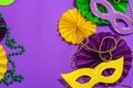 Festive Mardi Gras masquerade purple background. Fat Tuesday carnival, masks, beads, traditional decor Royalty Free Stock Photo