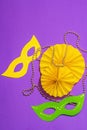 Festive Mardi Gras masquerade purple background. Fat Tuesday carnival, masks, beads, traditional decor Royalty Free Stock Photo