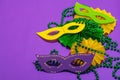 Festive Mardi Gras masquerade purple background. Fat Tuesday carnival, masks, beads, traditional decor Royalty Free Stock Photo