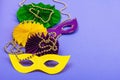 Festive Mardi Gras masquerade violet background. Fat Tuesday carnival, masks, beads, traditional decor Royalty Free Stock Photo