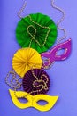 Festive Mardi Gras masquerade violet background. Fat Tuesday carnival, masks, beads, traditional decor Royalty Free Stock Photo