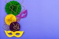 Festive Mardi Gras masquerade violet background. Fat Tuesday carnival, masks, beads, traditional decor Royalty Free Stock Photo