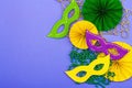 Festive Mardi Gras masquerade violet background. Fat Tuesday carnival, masks, beads, traditional decor Royalty Free Stock Photo