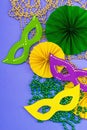 Festive Mardi Gras masquerade violet background. Fat Tuesday carnival, masks, beads, traditional decor Royalty Free Stock Photo