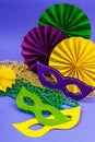 Festive Mardi Gras masquerade violet background. Fat Tuesday carnival, masks, beads, traditional decor Royalty Free Stock Photo