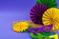 Festive Mardi Gras masquerade violet background. Fat Tuesday carnival, masks, beads, traditional decor Royalty Free Stock Photo