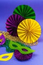 Festive Mardi Gras masquerade violet background. Fat Tuesday carnival, masks, beads, traditional decor Royalty Free Stock Photo