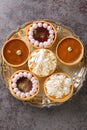 Festive mix tartlets with lemon curd, raspberry curd, nuts and chocolate close-up. Vertical top view Royalty Free Stock Photo