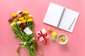 Festive morning concept buttercup flowers bouquet, gift box, cup of cappuccino, makarons cake, clean notebook, pen on the pink bac Royalty Free Stock Photo