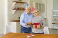 Loving older man congratulated his wife on the anniversary by giving her a gift and cake.