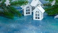 Festive new year decoration with wooden toy houses lights, green fir tree branch on blue background