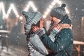 Festive New Year& x27;s mood, snow and romance. Loving couple warmly dressed on the background of a night street Royalty Free Stock Photo