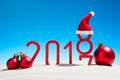 Festive New Years concept with Christmas balls a sunny tropical beach with the changing date 2017 - 2018 in red and copy space on Royalty Free Stock Photo