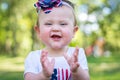 Festive one year old girl in the park on the 4th of July