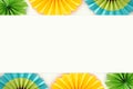 Festive and party background with colorful paper circle fans over wooden white background. Copy space.