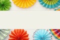 Festive and party background with colorful paper circle fans over wooden white background. Copy space.