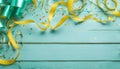 Festive party or carnival border of coiled streamers and confetti on a light blue green wood Royalty Free Stock Photo