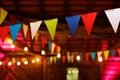 Festive party venue decorated with colorful pennant banners and string lights