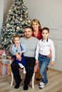 Festive people posing with gifts on the couch. Happy parents, children Royalty Free Stock Photo