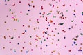 Festive pink background with many colorful stars and moons. Christmas, New Year or Birthday theme concept