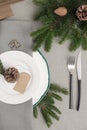 Festive place setting with beautiful dishware, cutlery and cone for Christmas dinner on grey table, flat lay Royalty Free Stock Photo